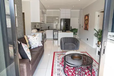 a living room with a couch and a table at Waterkloof on Main Sassy Modern Apartment in Pretoria