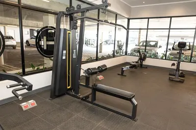 a gym with two treadmills and a simulator at Waterkloof on Main Sassy Modern Apartment in Pretoria