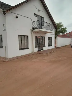 a white building with a balcony on the side at Majestic Haven Guesthouse in Mabopane