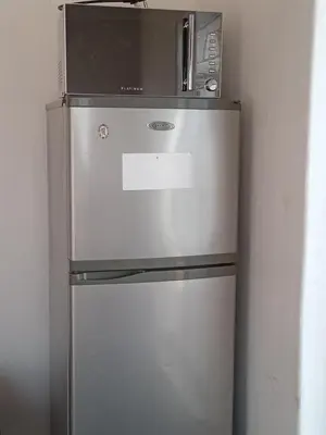 a refrigerator with a microwave on top of it at Majestic Haven Guesthouse in Mabopane