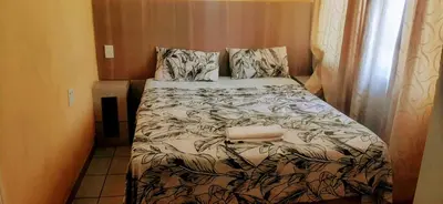 a small bedroom with a bed in a room at Majestic Haven Guesthouse in Mabopane