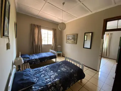 a bedroom with two beds and a window at Wildevy Accommodation in Thabazimbi