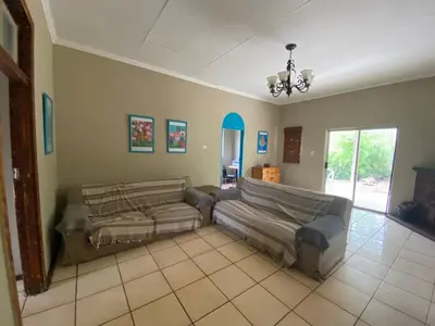 a living room with two couches and a chandelier at Wildevy Accommodation in Thabazimbi