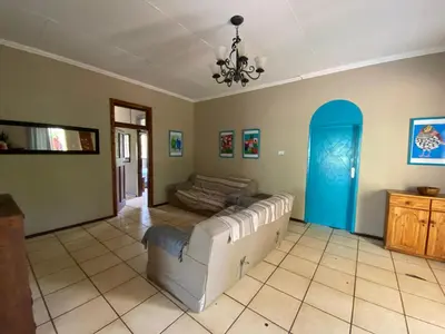a living room with a white couch and a blue door at Wildevy Accommodation in Thabazimbi