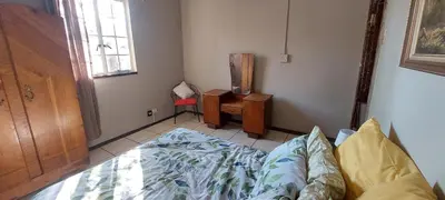 a bedroom with a bed and a table and a window at Wildevy Accommodation in Thabazimbi