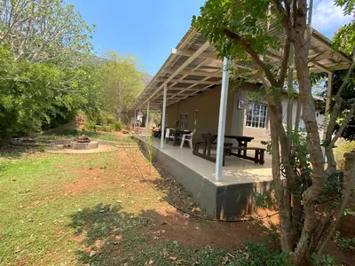 a house with a porch with a picnic table on it at Wildevy Accommodation in Thabazimbi