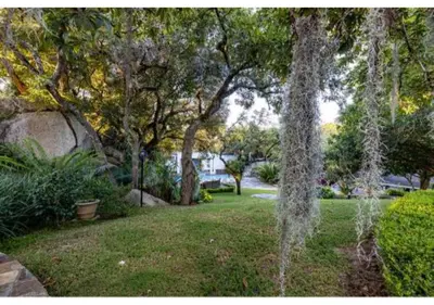 a garden with trees and grass and a field at Sheppard Boutique Hotel in Nelspruit