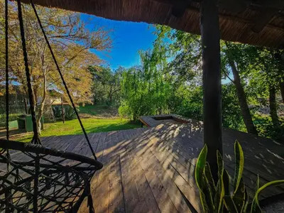 a porch with a swing and a yard at Lemón Villa in Bela-Bela