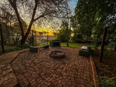 a brick patio with a fire pit in a park at Lemón Villa in Bela-Bela