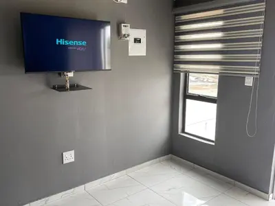 a living room with a tv and a window at Mukutsuri Luxury Apartments in Giyani
