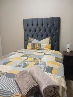 a bedroom with a bed with two towels on it at The Menlyn Hideaway in Pretoria
