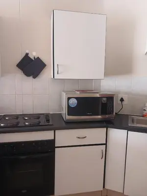 a kitchen with a microwave and a stove at The Menlyn Hideaway in Pretoria