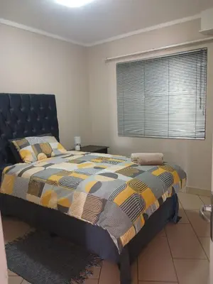 a bedroom with a bed with a large window at The Menlyn Hideaway in Pretoria