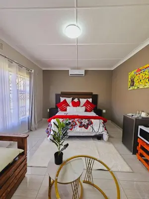 a bedroom with a large bed with red pillows at North ryde guest lodge southafrica in Kempton Park