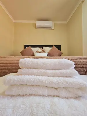 a pile of white towels sitting on top of a bed at North ryde guest lodge southafrica in Kempton Park