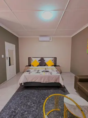 a bedroom with a bed and a table and chairs at North ryde guest lodge southafrica in Kempton Park