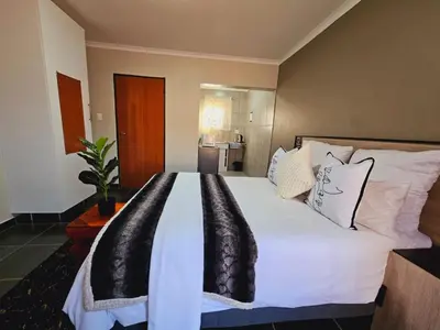 a bedroom with a large bed with white sheets and pillows at North ryde guest lodge southafrica in Kempton Park