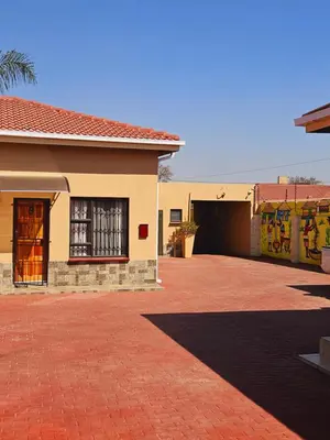 a building with a brick driveway next to a garage at North ryde guest lodge southafrica in Kempton Park