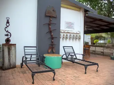 two black chairs sitting on a patio at De Kunst Huisje in Bela-Bela