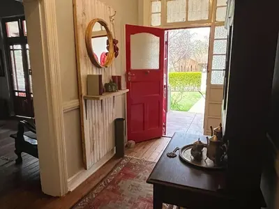 a red door in a living room with a table at De Kunst Huisje in Bela-Bela