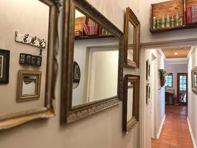a row of mirrors on a wall in a hallway at De Kunst Huisje in Bela-Bela