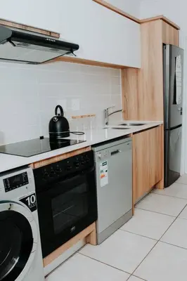 a kitchen with a stove and a sink and a dishwasher at The Blyde Lagoon Apartment in Pretoria
