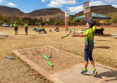 a boy swinging a bat at a baseball game at Olifants River Lodge Campsites by Dream Resorts in Botshabelo