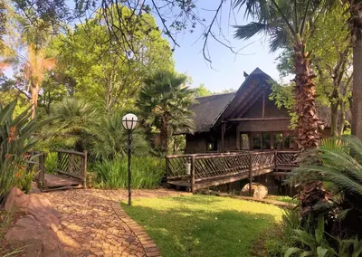 a house with a porch and a pathway in front of it at Olifants River Lodge Campsites by Dream Resorts in Botshabelo