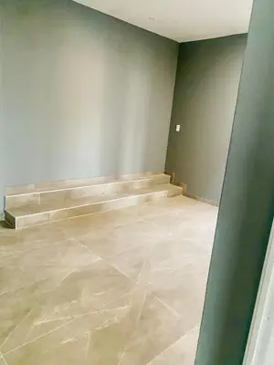 an empty room with a stone floor and stairs at 114 Zinnia in Midrand