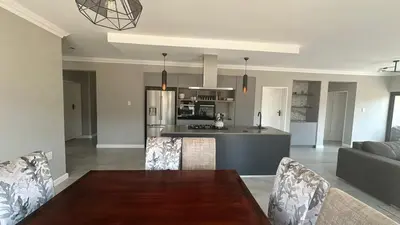 a dining room and kitchen with a table and chairs at CELONIA VILLA Euphoria 442 in Naboomspruit