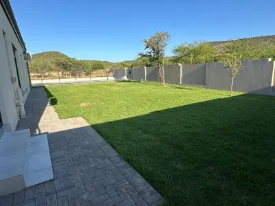 a yard with green grass and a fence at CELONIA VILLA Euphoria 442 in Naboomspruit