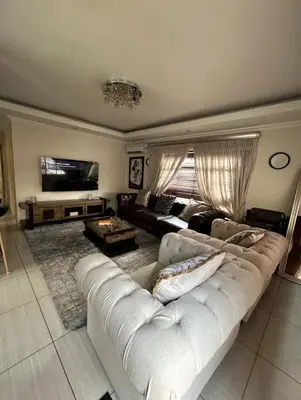 a living room with a white couch and a television at 3 Bed home Nelspruit Golden Crescent in Nelspruit