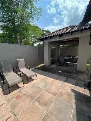 a patio with chairs and a table and a fence at 3 Bed home Nelspruit Golden Crescent in Nelspruit