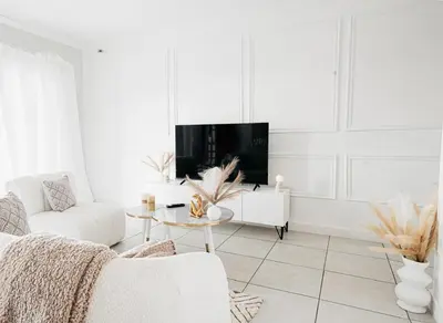 a white living room with a couch and a tv at Affordable Luxury villa at the Blyde in Pretoria