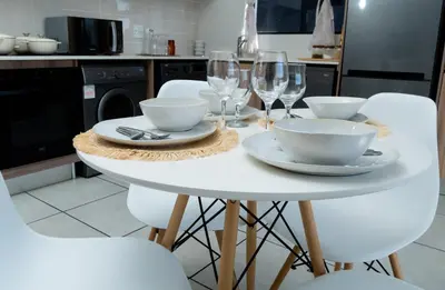 a white table with bowls and wine glasses on it at Affordable Luxury villa at the Blyde in Pretoria