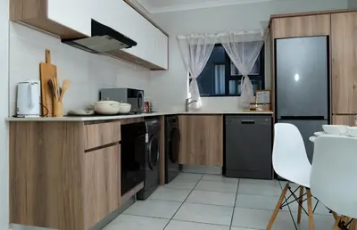 a kitchen with wooden cabinets and a black refrigerator at Affordable Luxury villa at the Blyde in Pretoria