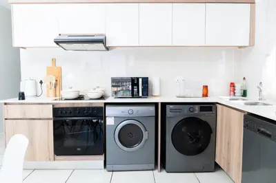 a kitchen with a washing machine and a dishwasher at Affordable Luxury villa at the Blyde in Pretoria