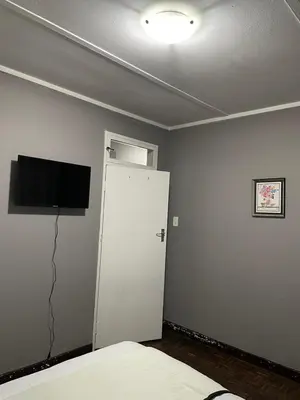 a bedroom with a white cabinet and a television at Palma de Mallorca in Kempton Park