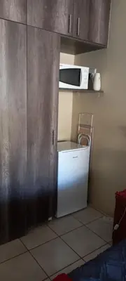 a small kitchen with a refrigerator and a microwave at Delutz Overnight Accommodation Room 1 in Polokwane