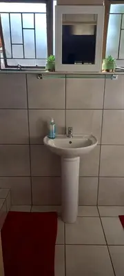 a bathroom with a sink and a window at Delutz Overnight Accommodation Room 1 in Polokwane