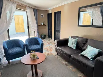 a living room with a couch and chairs and a table at Spacious stay-in 2bedroom apartment in Kempton Park