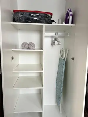 a white closet with white shelves and a tie at Spacious stay-in 2bedroom apartment in Kempton Park