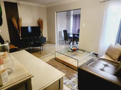 a living room with a couch and a table at Blue Button in Pretoria