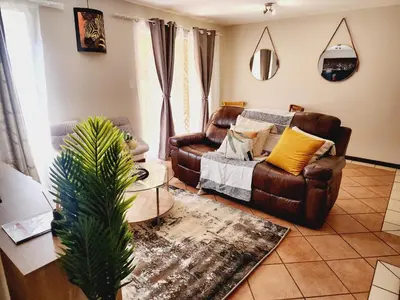 a living room with a couch and a chair at Blue Button in Pretoria