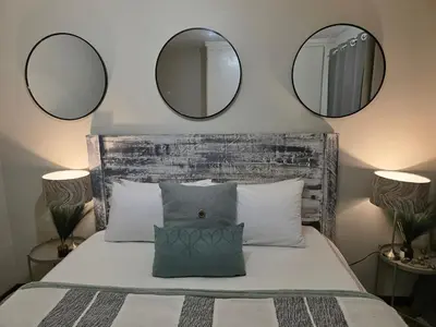 a bedroom with two mirrors above a bed at Blue Button in Pretoria