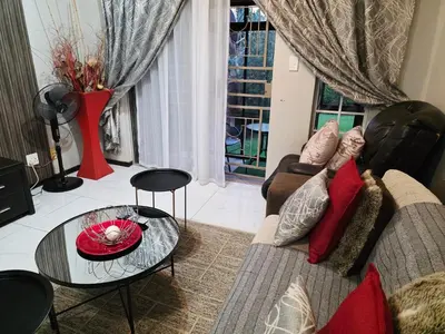 a living room with a couch and a glass table at Blue Button in Pretoria