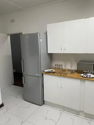 a kitchen with white cabinets and a stainless steel refrigerator at Travelers Standard in Kempton Park