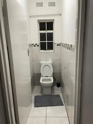 a small bathroom with a toilet and a window at Travelers Standard in Kempton Park