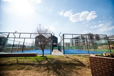 a batting cage with a tennis court in front of a building at K47 propertyzz in Midrand