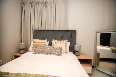 a bedroom with a large bed with a mirror at K47 propertyzz in Midrand